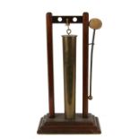 A trench art shell case table gong mounted on a hardwood stand.