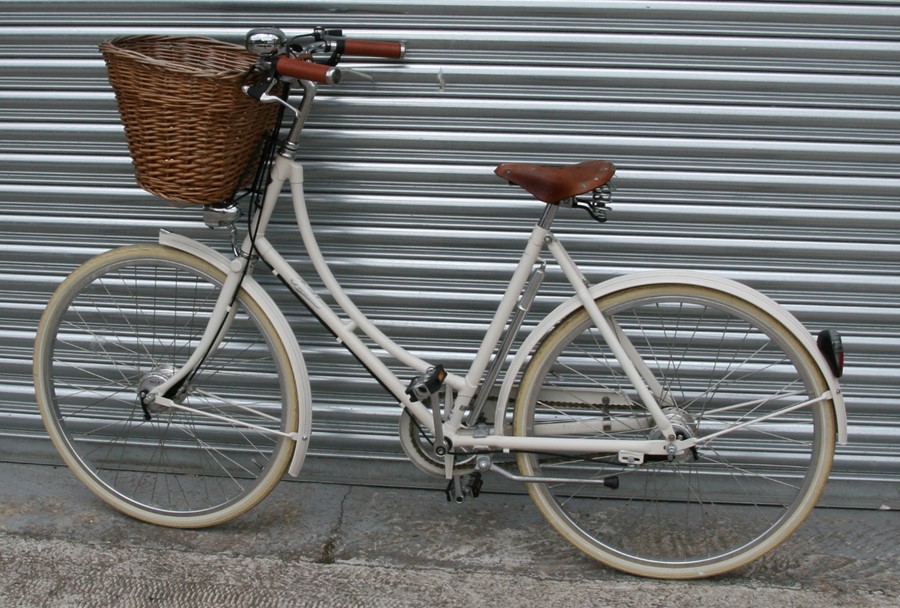 A Pashley vintage style ladies bicycle with leather Brookes saddle and wicker shopping basket.