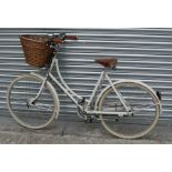 A Pashley vintage style ladies bicycle with leather Brookes saddle and wicker shopping basket.