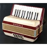 A Hohner Piccola 12 bass red plastic accordion..