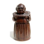 A 19th century Black Forest style carved tobacco or cigar jar in the form of a robed man reading a