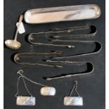An Edwardian silver pen tray, London 1910; together with a group of Georgian silver sugar tongs; a