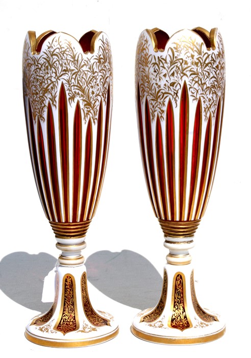 A fine pair of 19th century Bohemian cranberry glass overlaid vases with gilt decoration, 31cms (