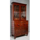An early 19th century inlaid mahogany secretaire bookcase, the pair of glazed doors with a shelved