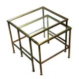 A nest of two brass & glass occasional tables, the largest 51cm (20ins) wide.