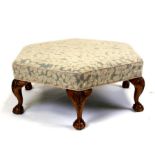 A large hexagonal upholstered footstool on cabriole legs with ball & claw feet, 107cms (42ins)