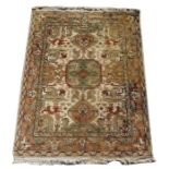 A Persian rug with three central medallions on a beige coloured ground, 191 by 142cms.Condition