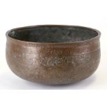 An early Persian copper bowl decorated with foliate scrolls and script, 24cms (9.5ins) diameter.