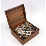 A quantity of loose buttons in a wooden box