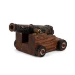 An early 20th century cast brass signal cannon mounted on a wooden carriage. Barrel length 14cms (