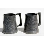 A pair of Chinese pewter tankards decorated with dragons, 11.5cms (4.5ins) high (2).