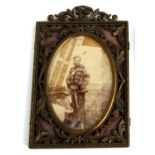 An oval pierced brass photograph frame with a photo of Henry Powell in Military dress, 21cms (8.