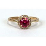 A 9ct gold dress ring set with a large central pink stone surrounded by white stones, approx UK size