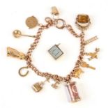 A 9ct rose gold charm bracelet with various gold charms to include a 10 shilling note, a Daly