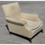 An Edwardian Howard style upholstered armchair.