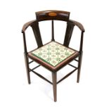 An Edwardian inlaid mahogany corner chair with upholstered seat, on square tapering legs.