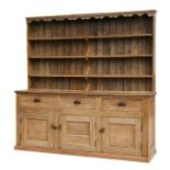 A large stripped pine country house dresser with three-tier plate rack above three frieze drawers