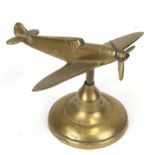 A brass model of the WW2 Supermarine Spitfire with spinning propeller mounted on its brass base.