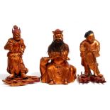 A group of three Chinese gilded wooden figures, a seated dignitary and two deities standing on