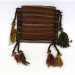 A Persian carpet salt bag with ornate tassels.