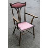 An Art Nouveau walnut armed chair with upholstered seat and headrest.