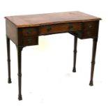 A mahogany writing table, the shaped rectangular top with an arrangement of five drawers, on