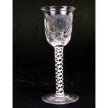 An 18th century style air twist stem wine glass, the bowl etched with an English rose, the stem with