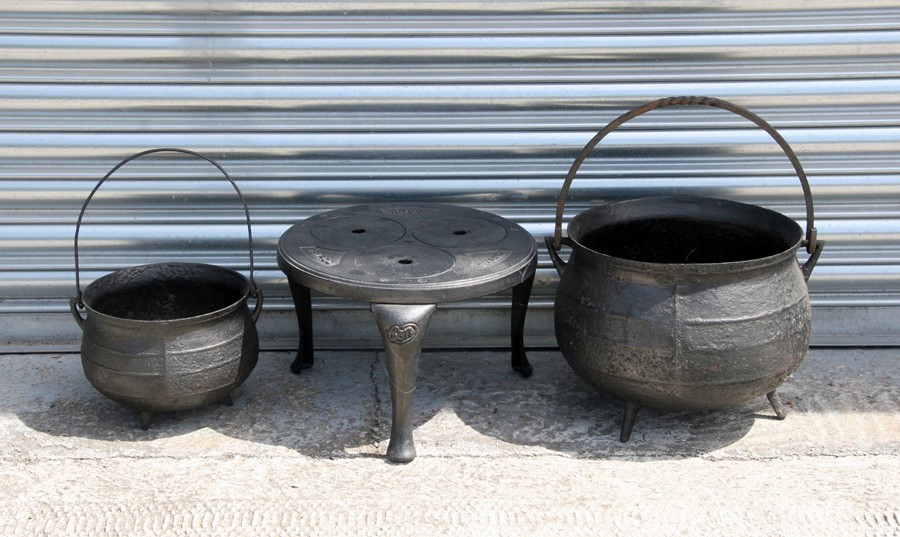 A large cast iron cauldron with ribbed decoration, 36cms (14ins) diameter; together with a similar