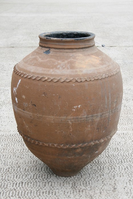A large terracotta olive jar, 63cms (24.75ins) high.