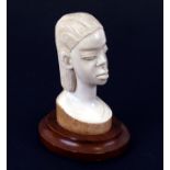 An early 20th century African ivory bust depicting a young woman, 15cms (6ins) high.