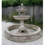 A two-tier weathered stoneware fountain and base of classical form, 175cm high, 210cm diameter.