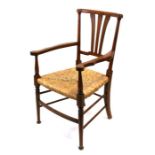 A fruitwood country carver chair with rush seat, on turned front supports.