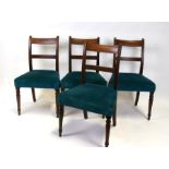 A set of four early 19th century mahogany dining chairs with upholstered seats, on turned front