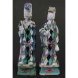 A pair of 18th / 19th century Chinese clobbered figures wearing harlequin robes, the largest