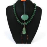 A Chinese jade or green hardstone court necklace pendant together with a Chinese jade/hardstone