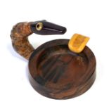A novelty hardwood ashtray in the form of a snake with cherry amber Bakelite head, 7cms (2.75ins)