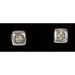 A pair of 18ct white and yellow gold square stud earrings set with two round brilliant cut diamonds,