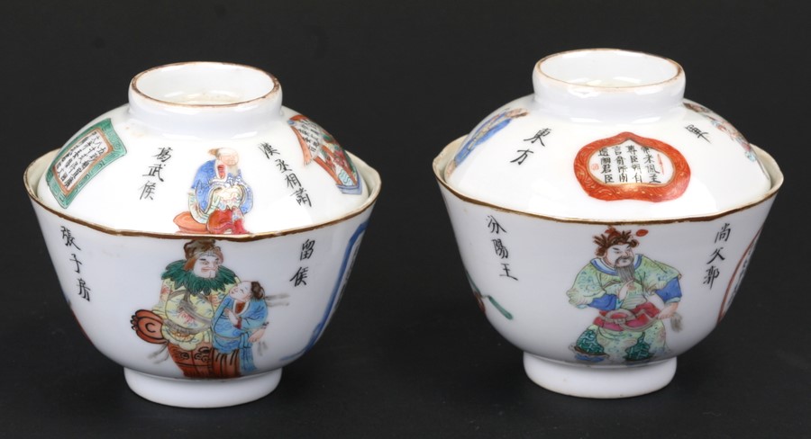 A pair of Chinese Wu Shuang porcelain bowls and covers decorated with figures and calligraphy, red