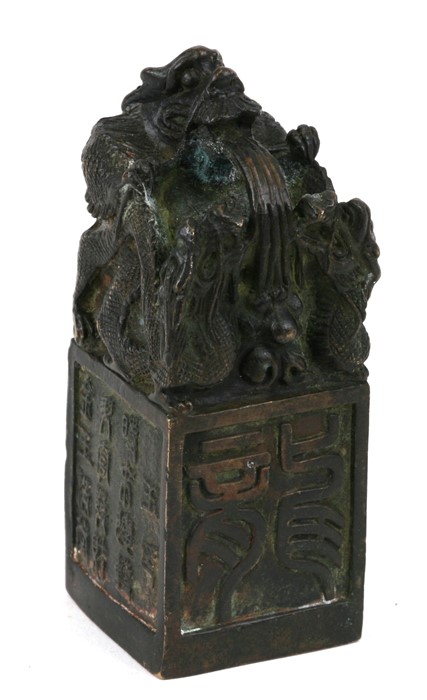A Chinese bronze seal, the top with a mythical beast, on a square platform with character marks,