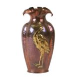 An Arts & Crafts copper & brass vase decorated in relief with a heron or liver bird, 32cms (12.5ins)