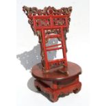 A Chinese gilded and red lacquer stand surmounted with a pair of dragons, 56cms (22ins) high.