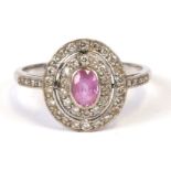 An 18ct white gold pink sapphire and diamond ring, the central oval sapphire surrounded by two bands