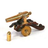 A brass model of a cannon on a wooden carriage, 20cms (8ins) long.