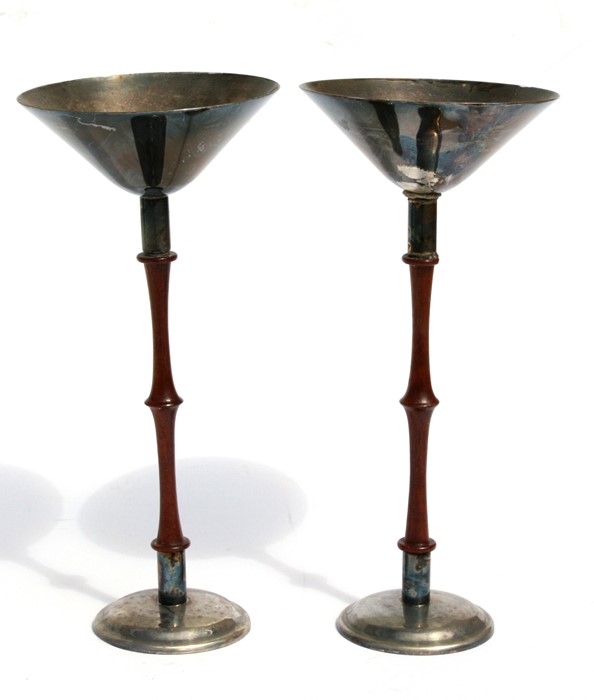 A pair of Austrian Hammercraft silver plated stands with turned mahogany columns, 24cms (9.5ins)