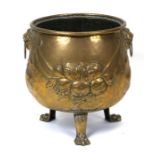 A Georgian brass log bin with lion mask handles, on three lion paw feet, 43cms (17ins) high.