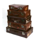 Five vintage graduated suitcases, some with period travel labels, the largest 70cm (27.5ins) wide (