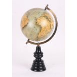 A terrestrial globe on an ebonised stand, 41cms (16ins) high.
