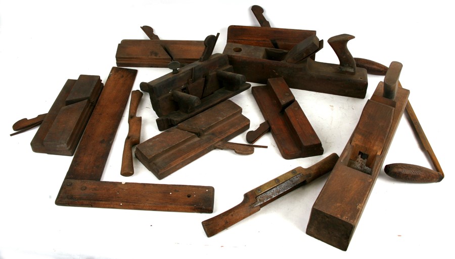 A collection of woodworker's tools including planes, moulding planes and other similar items.