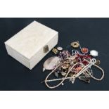 A quantity of costume jewellery in a white jewellery box.