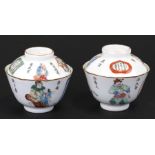 A pair of Chinese Wu Shuang porcelain bowls and covers decorated with figures and calligraphy, red